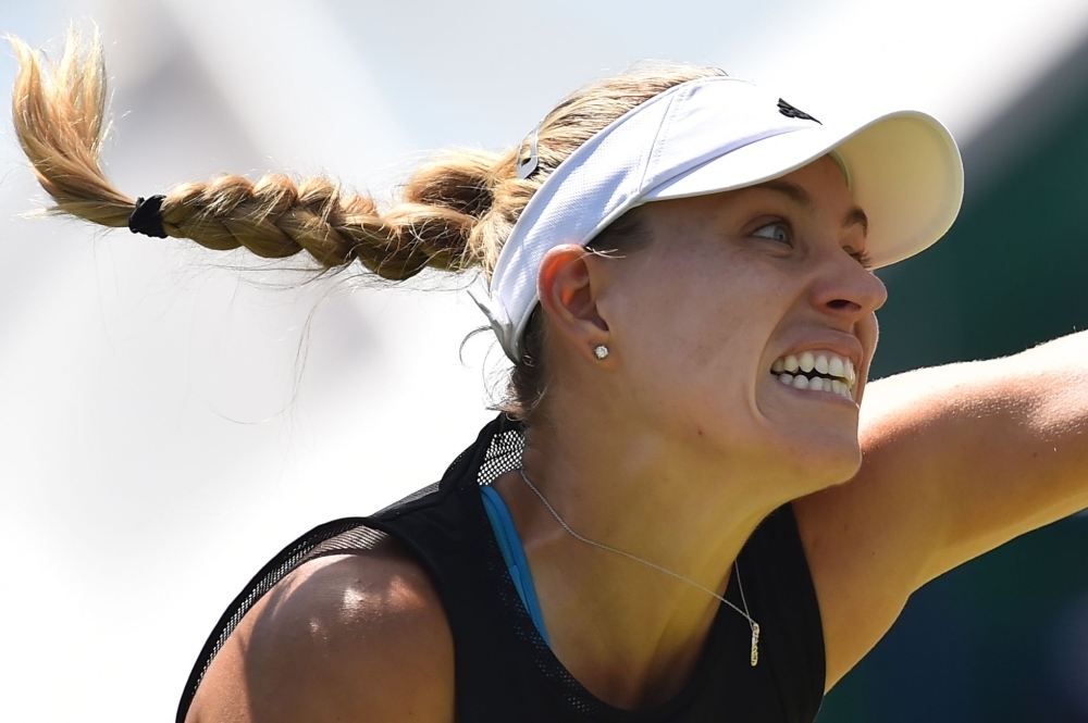 Germany's Angelique Kerber serves to Romania's Simona Halep during their women's singles quarterfinal match at the WTA Nature Valley International tennis tournament in Eastbourne, southern England on Thursday. — AFP