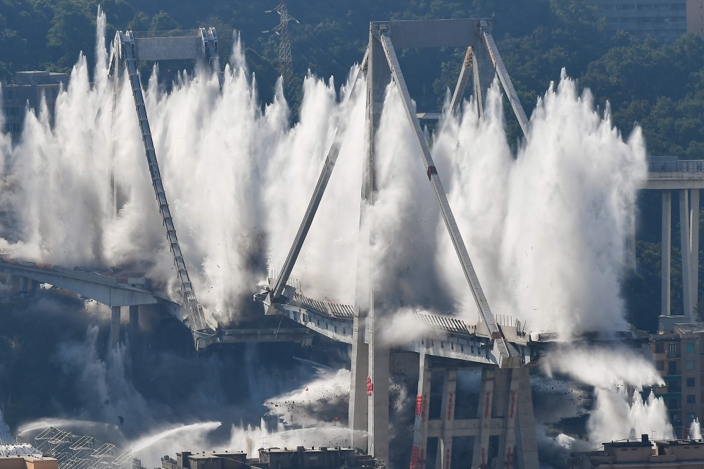 Explosive charges blow up the eastern pylons of Genoa's Morandi motorway bridge in Genoa, Italy, on Friday. — AFP