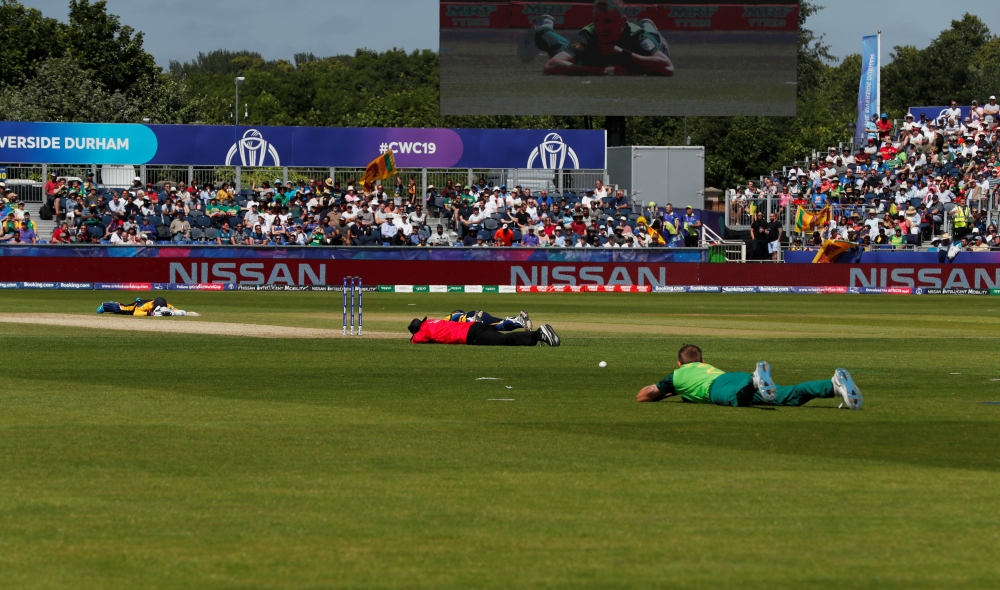 The umpire, Sri Lanka and South Africa players lie on the ground to avoid bees during the ICC Cricket World Cup match at the  Emirates Riverside, Chester-Le-Street, Britain on Friday. — Reuters