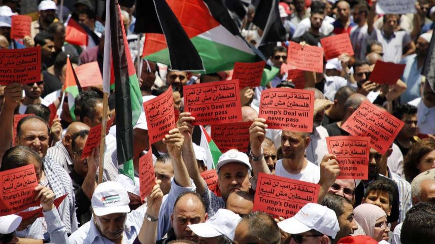 Palestinian demonstrators carry banners and national flags during a protest last week in Nablus against the US-sponsored Middle East economic conference in Bahrain. — AFP