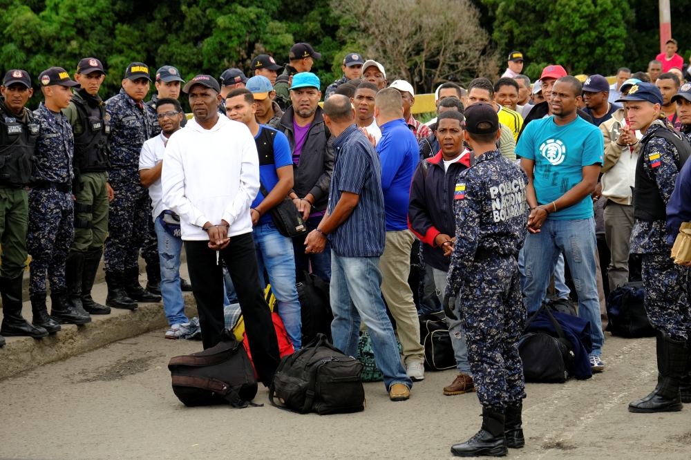 Members of Venezuelan security forces stand guard at the Simon Bolivar International Bridge as a group of Colombian citizens, who had been detained almost three years ago on allegations they were paramilitaries, wait to be deported back to Colombia, in San Antonio del Tachira, Venezuela, Sunday. -Reuters