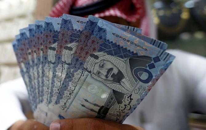 FILE PHOTO: A Saudi money changer displays Saudi Riyal banknotes at a currency exchange shop in Riyadh, Saudi Arabia July 27, 2017. REUTERS/Faisal Al Nasser