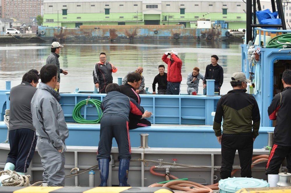 Japanese fishermen on their whaling ships wait for departure at a port in Kushiro, Hokkaido Prefecture on July 1, 2019. Japanese fishermen set sail on July 1 to hunt whales commercially for the first time in more than three decades after Tokyo's controversial withdrawal from the International Whaling Commission (IWC) triggered outrage from environmental groups. / AFP / Kazuhiro NOGI
