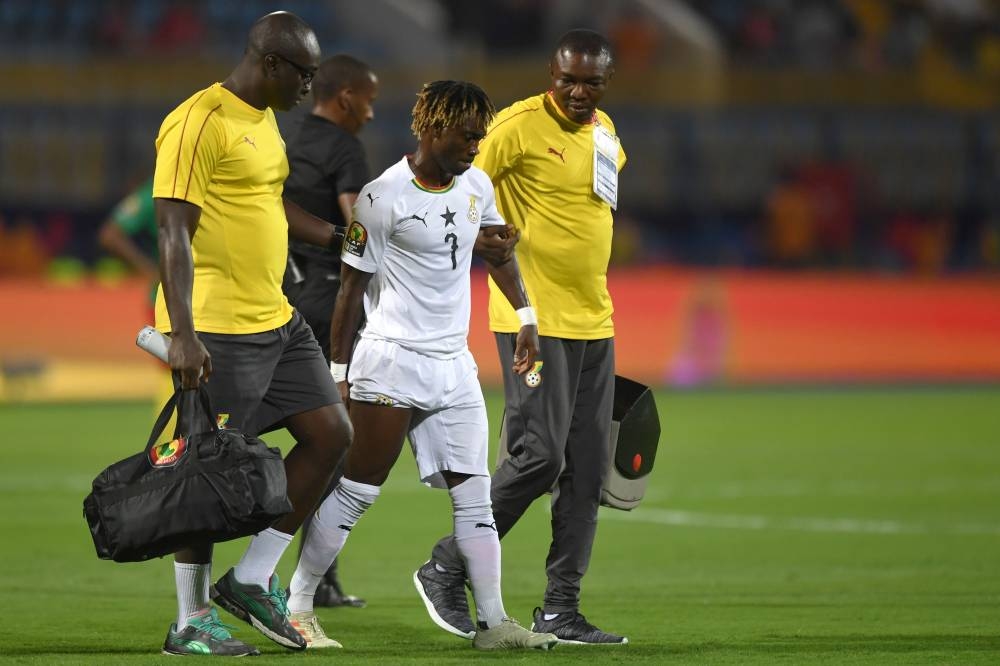 Ghana's midfielder Christian Atsu (C) is escorted off the pitch for treatment during the 2019 Africa Cup of Nations (CAN) Group F football match between Cameroon and Ghana at the Ismailia Stadium on Saturday. — AFP