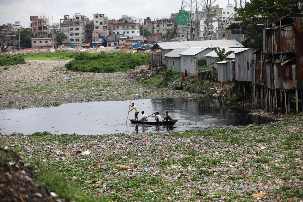People cross the heavily polluted Buriganga river by boat in Dhaka, Bangladesh, on Tuesday. — Reuters