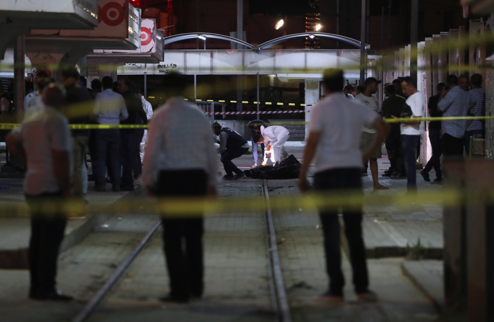 Authorities inspect the scene after a man reported to be wearing an explosive belt died in the Intilaka area in Tunis on Monday. -Reuters