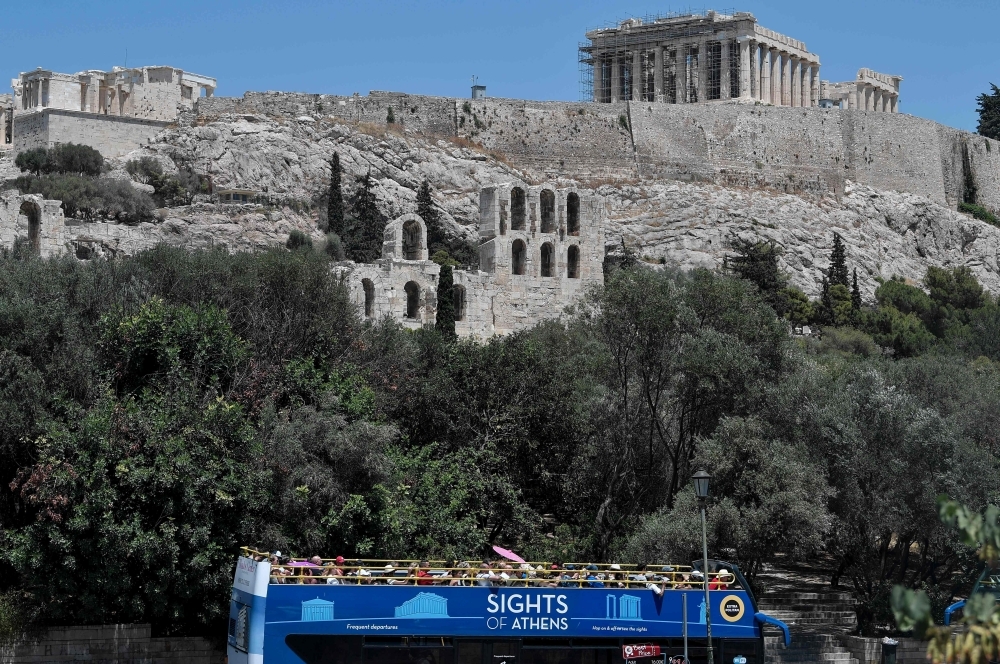 A tourist bus drives near the empty Acropolis archaeological site in Athens, Greece, on Thursday. — AFP