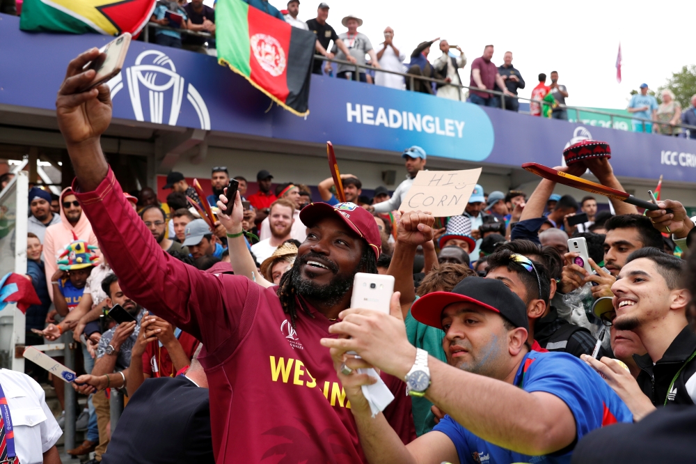 West Indies' Chris Gayle poses for a photo with fans as he celebrates after the ICC Cricket World Cup match against Afghanistan at the Headingley, Leeds, Britain on Thursday. — Reuters