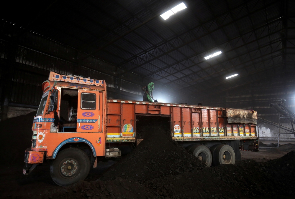 A worker shovels coal in a supply truck at a yard on the outskirts of Ahmedabad, India, in this Oct. 25, 2018, file photo. — Reuters