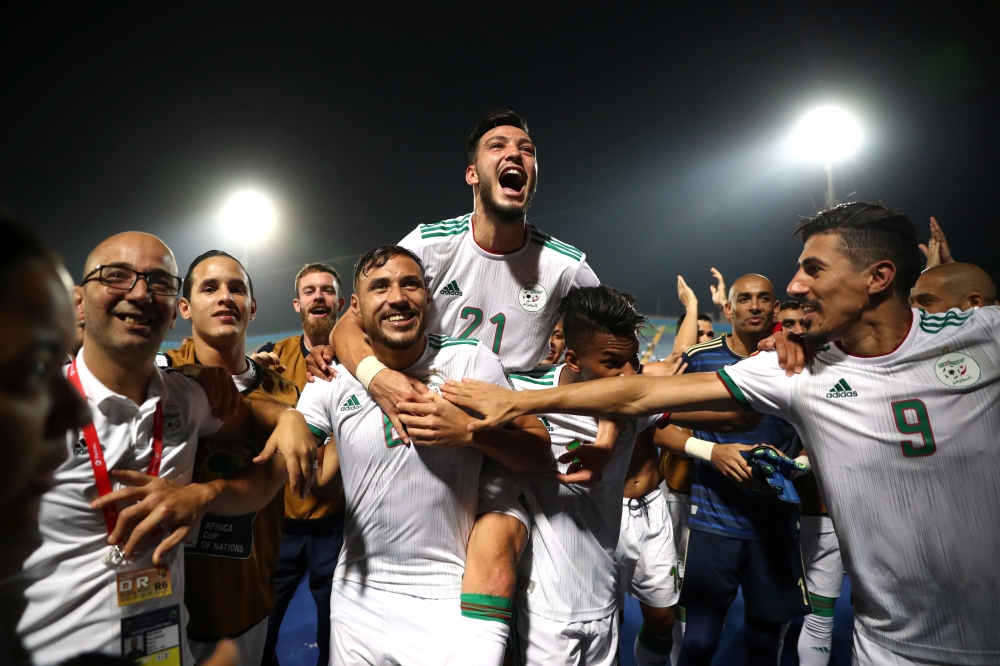 Algerian players celebrate winning the Africa Cup of Nations round 16 match against Guinea in Cairo, Egypt, on Sunday. — Reuters