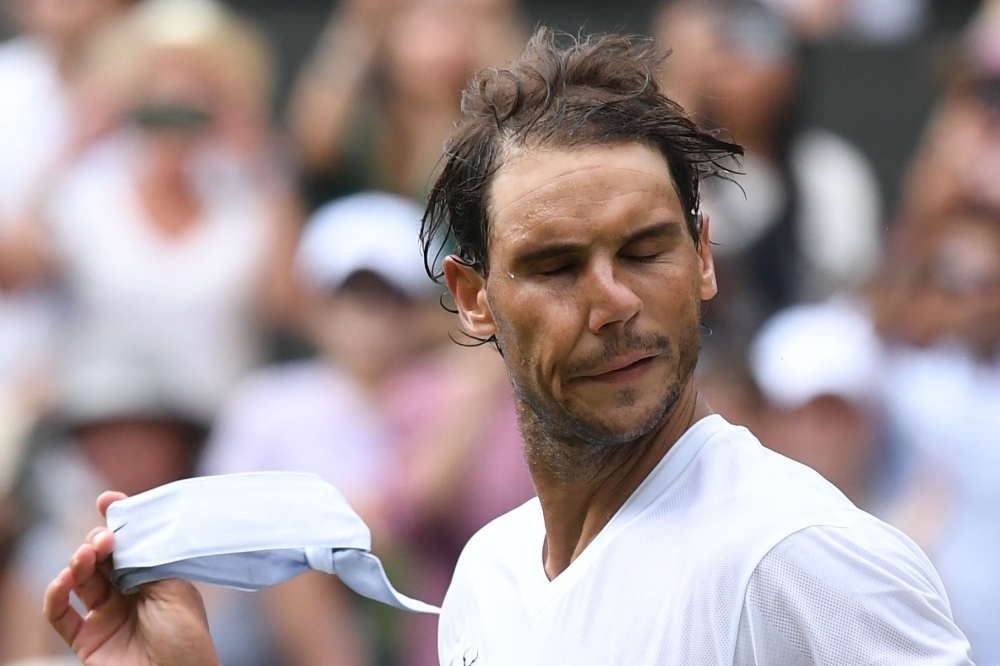 Spain's Rafael Nadal removes his head-band after beating Portugal's Joao Sousa during their men's singles fourth round match on the seventh day of the 2019 Wimbledon Championships at The All England Lawn Tennis Club in Wimbledon, southwest London, on Monday. — AFP