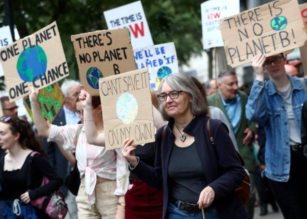 People carry placards as they attend a climate change demonstration in London on June 26. -Reuters