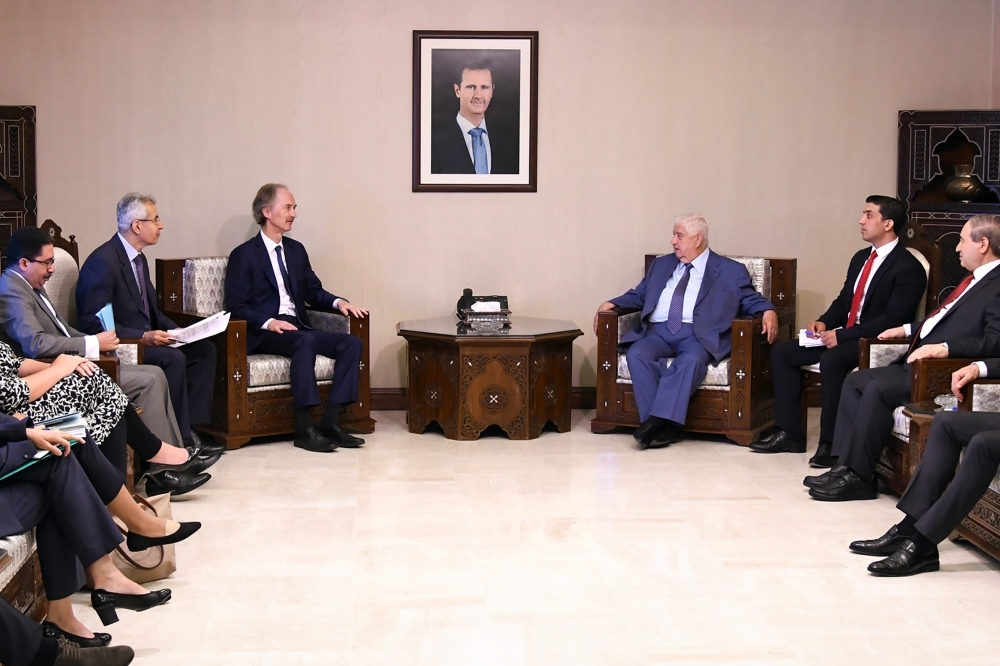 A handout picture released by the official Syrian Arab News Agency (SANA) on Wednesday shows United Nations special envoy to Syria Geir Pedersen, center left, meeting with Syrian Foreign Minister Walid Al-Moallem, center right, in the Syrian capital Damascus . — AFP