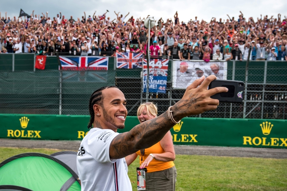 Mercedes' British driver Lewis Hamilton takes a selfie photograph with his fans at Silverstone motor racing circuit in Silverstone, central England, on Thursday ahead of the British Formula One Grand Prix. — AFP