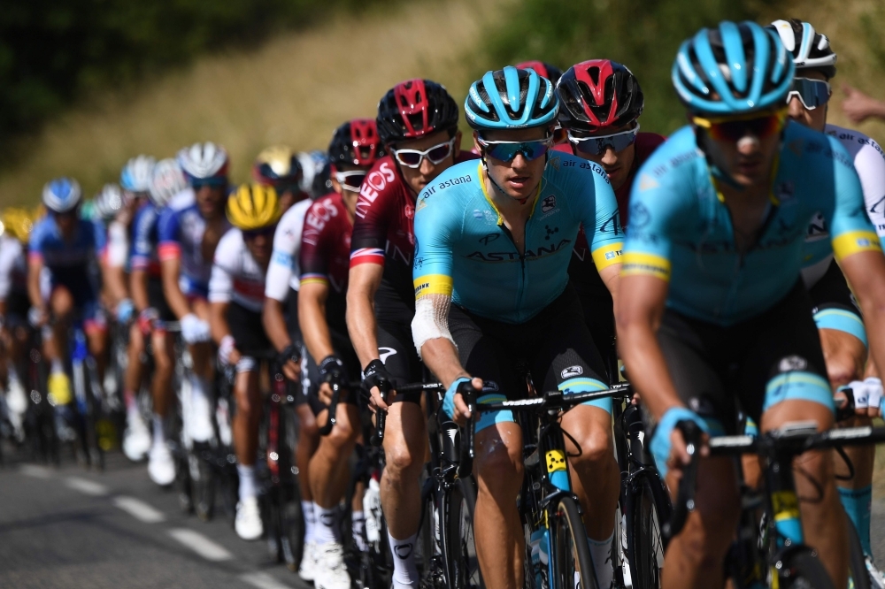 Denmark's Jakob Fuglsang (2ndR) and Great Britain's Geraint Thomas (behind) ride in the pack during the eighth stage of the 106th edition of the Tour de France cycling race between Macon and Saint-Etienne, on Saturday. — AFP