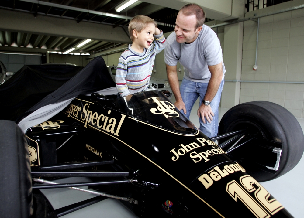 FILE PHOTO: Brazilian Formula One driver Rubens Barichello of Ferrari, talks to his son Eduardo Barrichello, who stands inside the cockpit of Ayrton Senna's old Lotus Formula One car, at the Interlagos race track, in Sao Paulo, October 18, 2004. The final round of the 2004 Formula One World Championship, the Brazilian GP, will be held in Sao Paulo on October 24. REUTERS/Paulo Whitaker  PW/File Photo