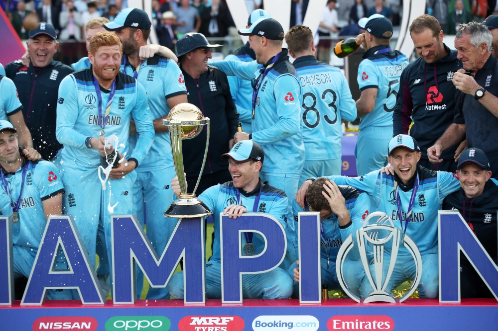 England's Eoin Morgan and teammates celebrate winning the world cup with the trophy after beating New Zealand in the ICC Cricket World Cup Final at  Lord's, London, Britain, on Sunday. — Reuters