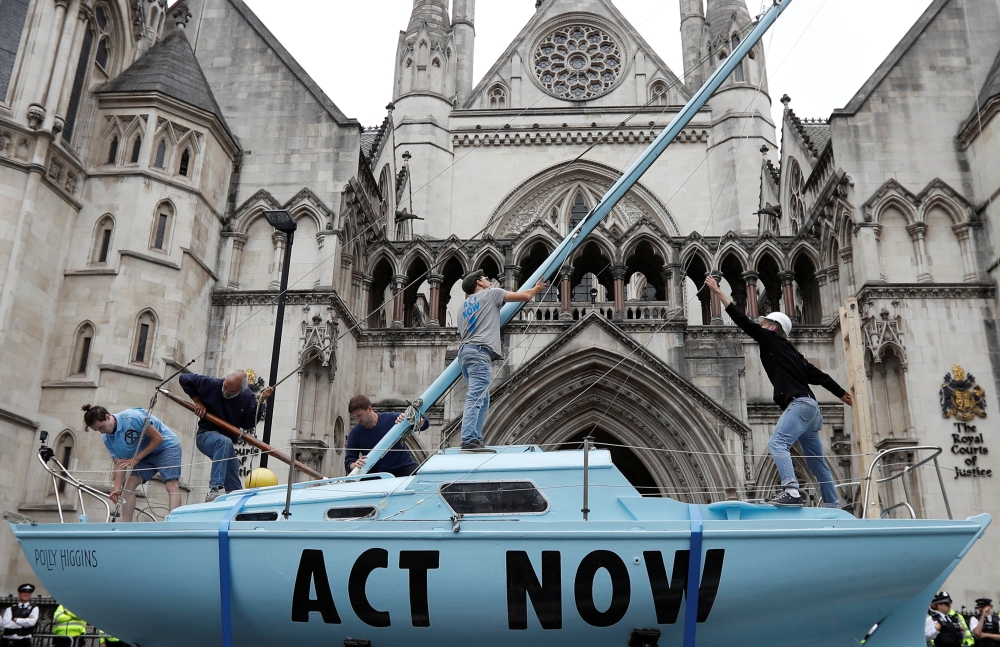 Extinction Rebellion climate activists raise a mast on their boat during a protest outside the Royal Courts of Justice in London on Monday. -Reuters photo