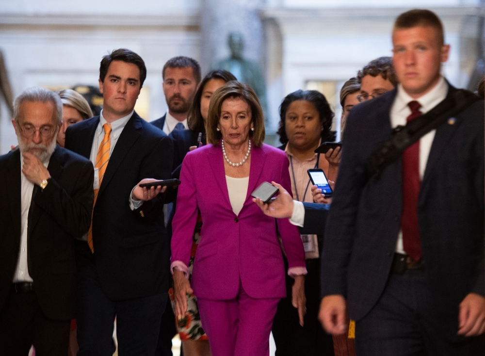 US speaker of the House, Nancy Pelosi walks with reporters, before the Democrat controlled House of Representatives passed a resolution condemning US President Donald Trump for his 