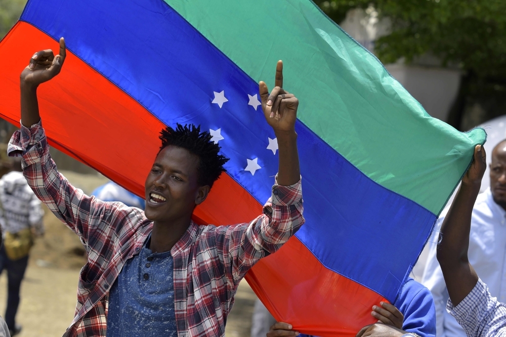 A young man reacts in front of the unofficial green, blue and red flag of the advocated region for the Sidama ethnic group as people of the Sidama ethnic group, the largest in southern Ethiopia, celebrate at Hawassa city over plans by local elders to declare the establishment of a breakaway region for the Sidama later this week, in Awasa, July 15, 2019.  -AFP photo