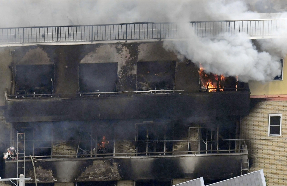 An aerial view shows smoke and flame rise from the three-story Kyoto Animation building which was torched in Kyoto, western Japan, on Thursday. — Reuters