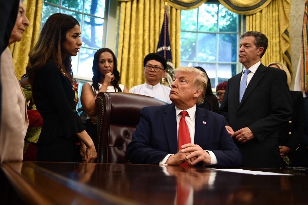 US President Donald Trump meets with survivors of religious persecution in the Oval Office of the White House in Washington on Wednesday. — AFP