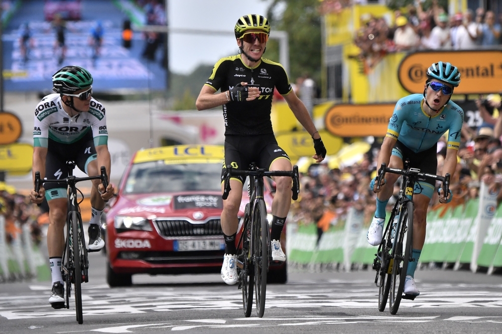 Great Britain's Simon Yates (C), flanked by Austria's Gregor Muhlberger (L) and Spain's Peio Bilbao, celebrates as he wins on the finish line of the twelfth stage of the 106th edition of the Tour de France cycling race between Toulouse and Bagneres-de-Bigorre, in Bagneres-de-Bigorre on Thursday. —  AFP