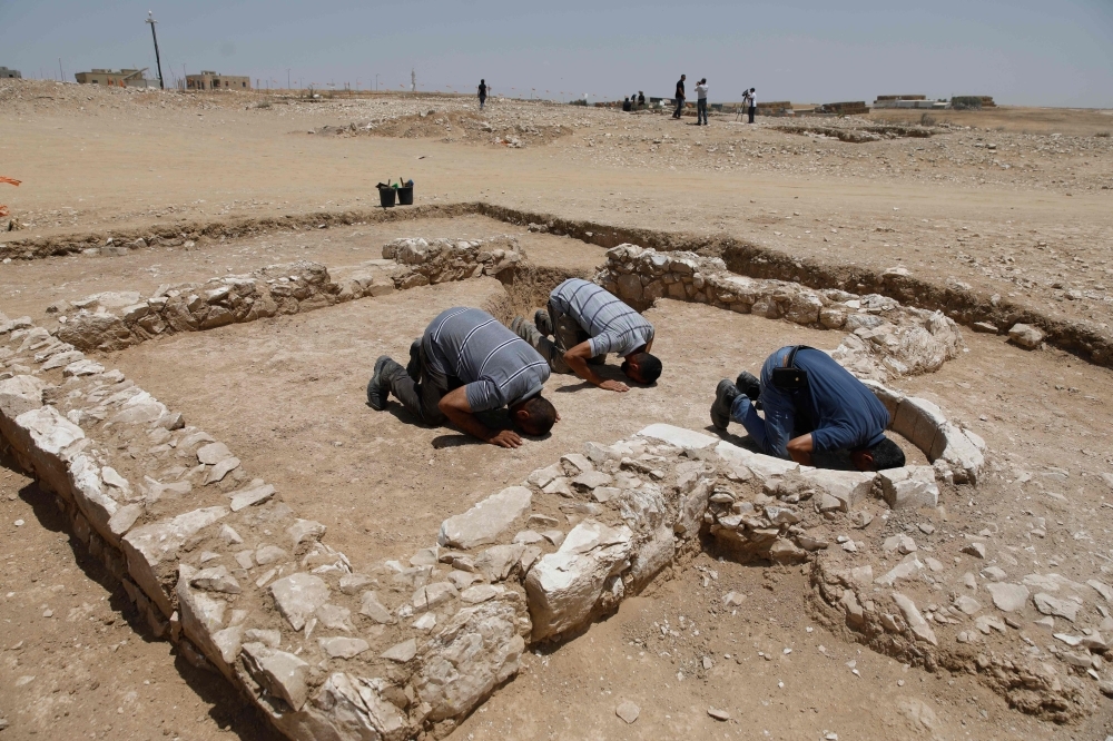 Muslim workers of Israel's antiquities authority pray at the newly discovered remains of an ancient rural mosque, dating back to the era between the 7th and the 8th centuries, in the Israeli Bedouin town of Rahat in the Negev desert on Thursday. — AFP