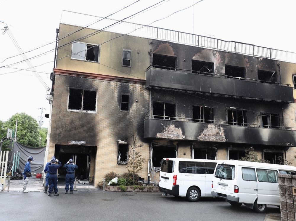 Japanese police officers inspect the scene where over 30 people died in a fire at the Kyoto Animation studio building in Kyoto on Friday. — AFP