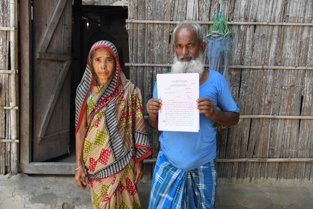 Mohammed Rehat Ali, right, 71, one of many to fall foul of a citizenship process in the north-eastern Indian state of Assam, holds a Supreme Court of India's order declaring him an Indian citizen as he stands with his wife Joiful Begum at his home at Khopnikuchi village in Assam's Kamrup district in this July 1, 2019 file photo. — AFP