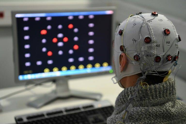 Progress is being made brain-computer interface technology, an example of which is seen at a French laboratory in 2017, but scientists say a vision outlined by Elon Musk to mesh brains and computers using artificial intelligence remains far off. — AFP