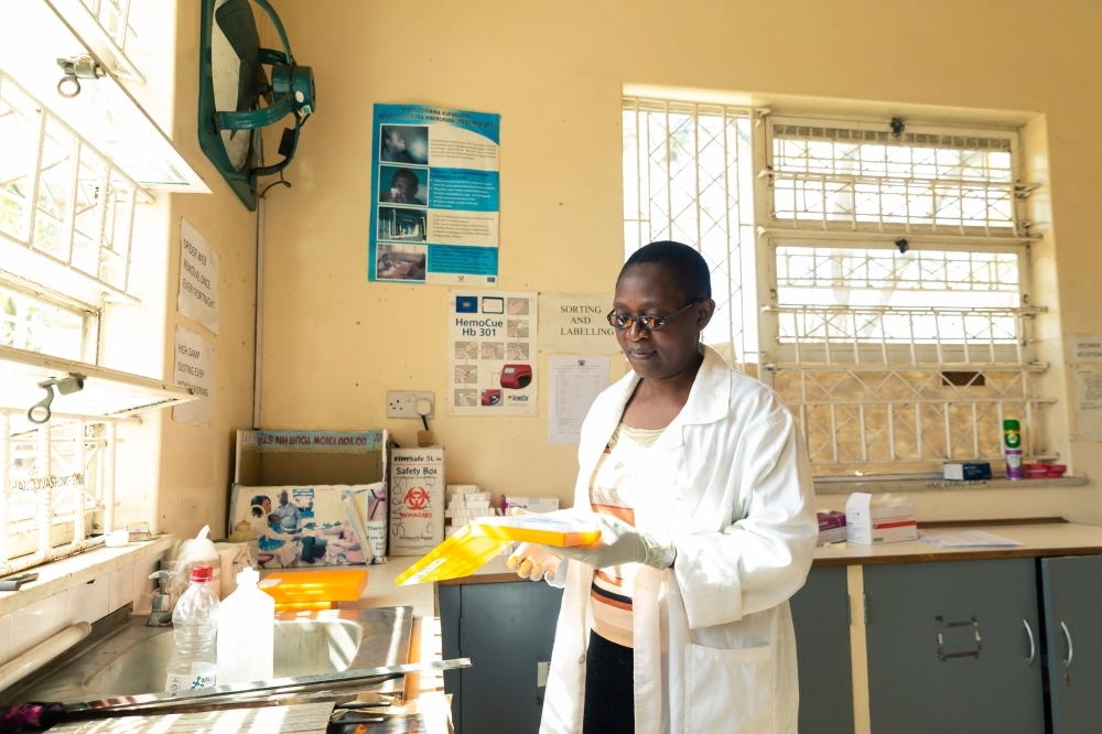 Microscopist Mazvita Chataurwa prepares slides to conduct tests on patient's sputum samples in an on-site laboratory, at Rutsanana Polyclinic in Glen Norah township, Harare on June 24. -AFP photo