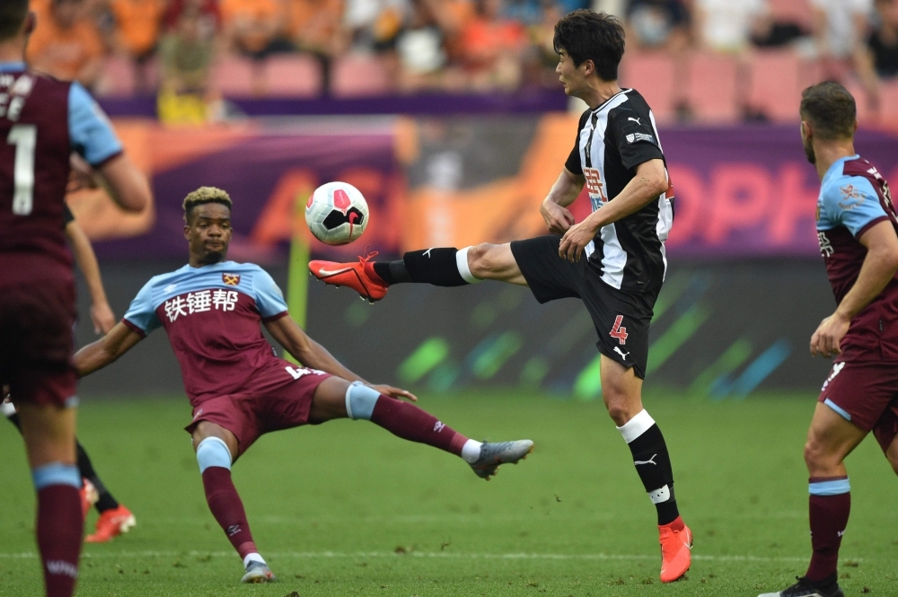 West Ham's Grady Diangana (L) vies for the ball with Newcastle United's Sung Yueng Ki (R) during their match for third place in the 2019 Premier League Asia Trophy football tournament at the Hongkou Stadium in Shanghai on Saturday. — AFP
