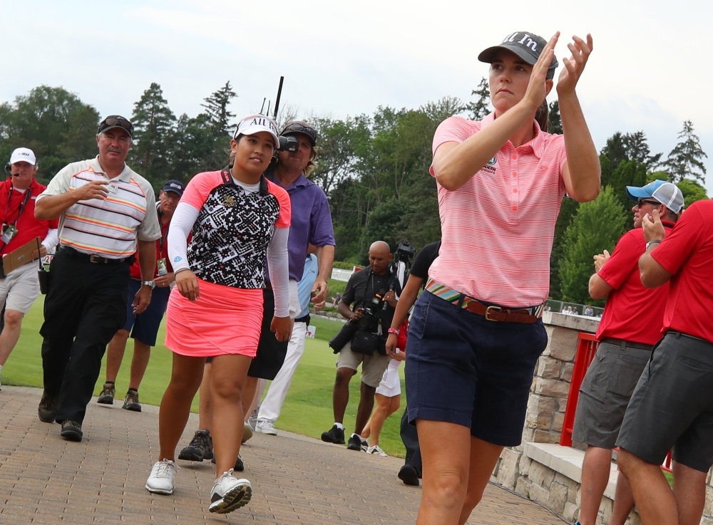 Teammates Cydney Clanton of the United States (R) and Jasmine Suwannapura of Thailand walk off the 18th green after winning the Dow Great Lakes Bay Invitational at Midland Country Club in Midland, Michigan, Saturday. — AFP