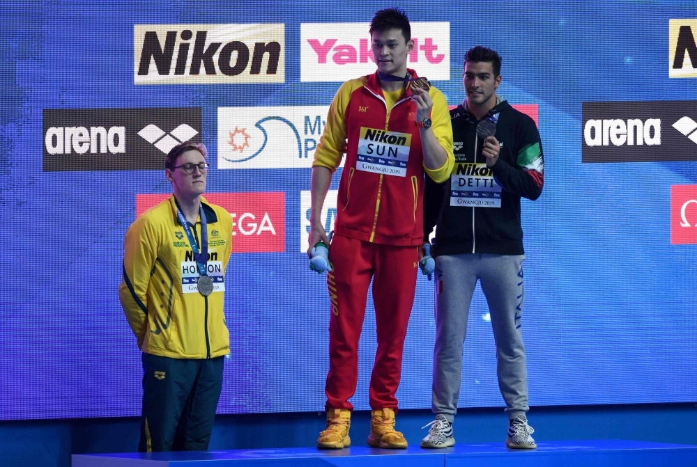Silver medalist Australia's Mack Horton (L) refuses to stand on the podium with gold medalist China's Sun Yang (C) and bronze medalist Italy's Gabriele Detti after the final of the men's 400m freestyle event during the swimming competition at the 2019 World Championships at Nambu University Municipal Aquatics Center in Gwangju, South Korea, on Sunday. — AFP