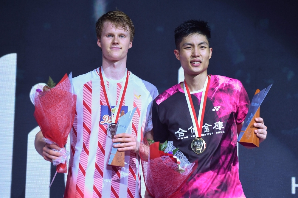 Winner Chou Tien-chen (R) of Taiwan and runner up Anders Antonsen (L) of Denmark pose for photographers following their men's singles final match at the Indonesian Open Badminton tournament in Jakarta, on Sunday. —  AFP