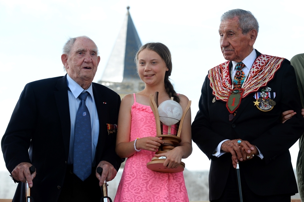 Swedish climate activist Greta Thunberg, flanked by WWII veteran and native American Charles Norman Shay (R), sponsor of the Freedom Award, and French WWII veteran Leon Gautier, poses with the Normandy 'Freedom prize' during the award ceremony on Sunday in Caen, Western France. — AFP