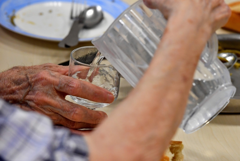 People serve water to each others in a residence for elderly people in Bordeaux, southwestern France, on Monday during a heat wave in the region. — AFP