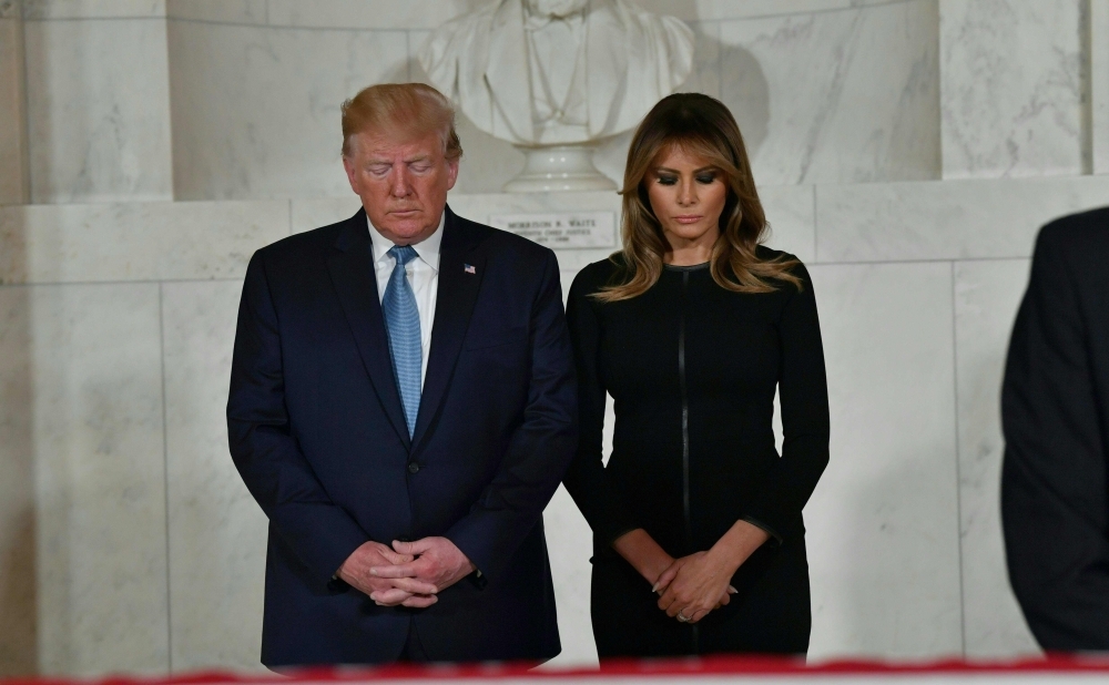 US President Donald Trump and First Lady Melania Trump pay their respects before the flag-draped casket of late Supreme Court Justice John Paul Stevens in the Great Hall of the Supreme Court in Washington on Monday. — AFP
