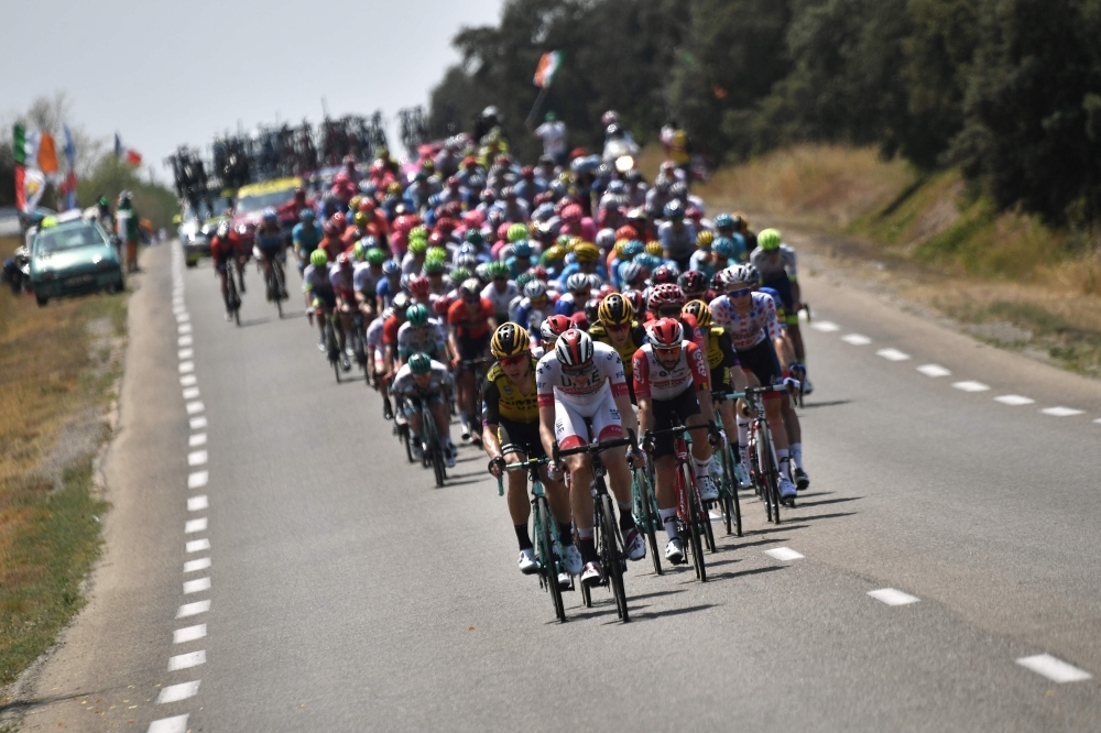 The pack rides during the sixteenth stage of the 106th edition of the Tour de France cycling race between Nimes and Nimes, in Nimes, on Tuesday. It will be hot work for the peloton in the Tour de France as temperatures hit the 40 degrees mark this week. — AFP