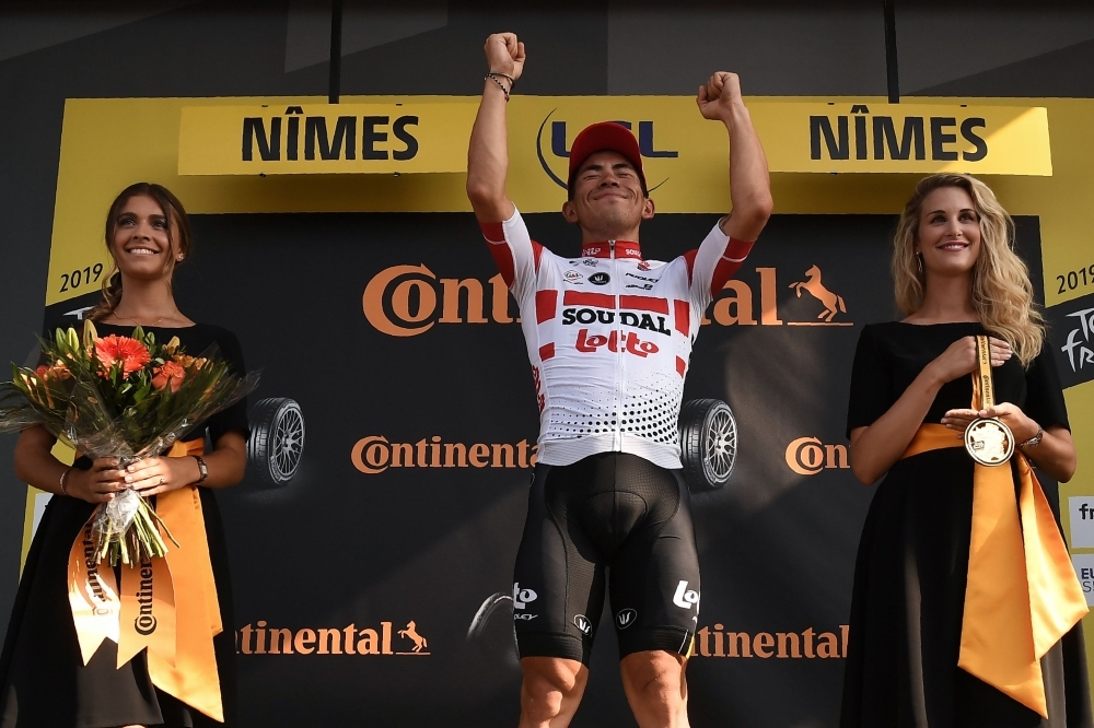 Stage winner Australia's Caleb Ewan (C) celebrates his victory on the podium of the sixteenth stage of the 106th edition of the Tour de France cycling race between Nimes and Nimes, in Nimes, on Tuesday. — AFP