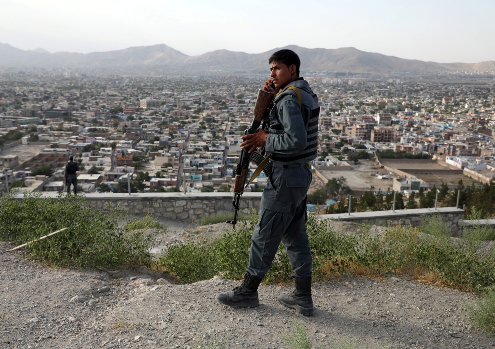 An Afghan policeman keeps watch at a hilltop in Kabul, Afghanistan, on Tuesday. — Reuters