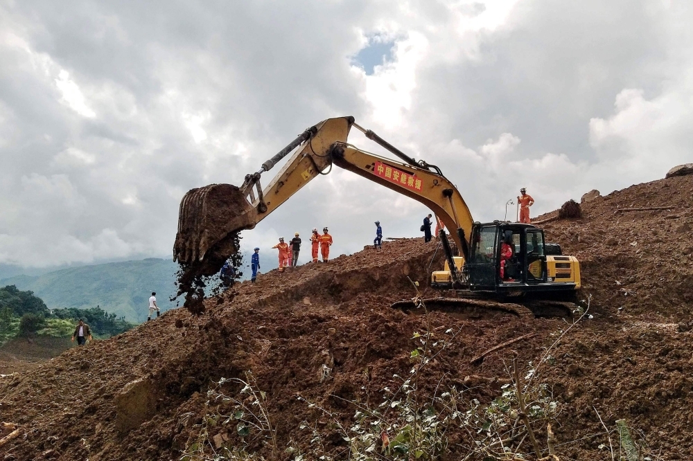 An excavator and rescuers work at the site of a landslide in Liupanshui in China's southwestern Guizhou province on Wednesday. — AFP