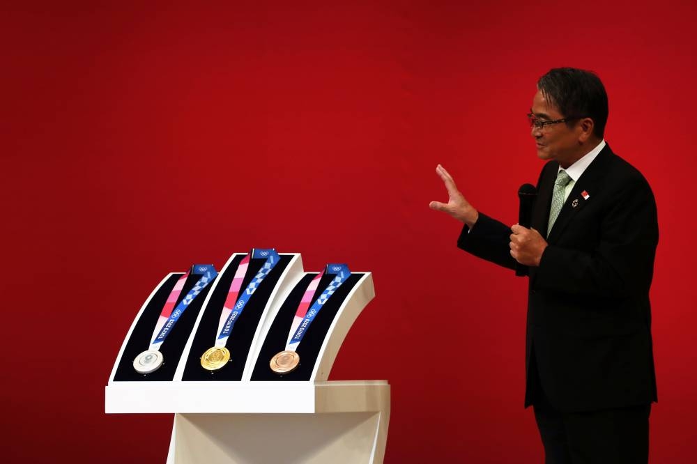 The medals for the Tokyo 2020 Olympic Games are unveiled as their designer, Junichi Kawanishi, speaks during a ceremony marking one year before the start of the games in Tokyo on Wednesday. Tokyo entered the final leg of its marathon Olympic preparations, marking a year until the 2020 Games open with officials promising a high-tech but eco-friendly event.— AFP