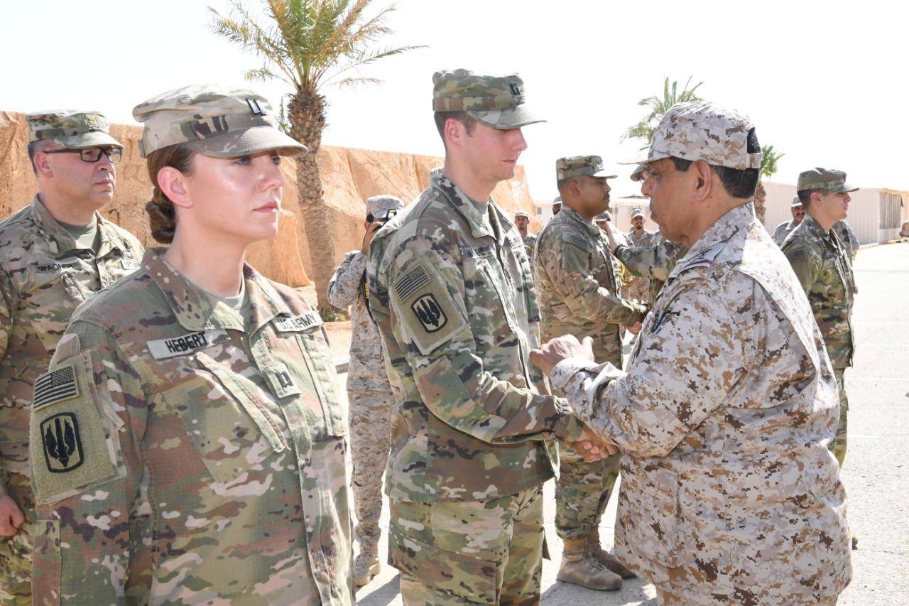 Commander of the Saudi Royal Land Forces Lt. Gen. Fahd Bin Abdullah Al-Mutair congratulating a member of the US forces, which had participated in the joint military exercises with Saudi forces —  