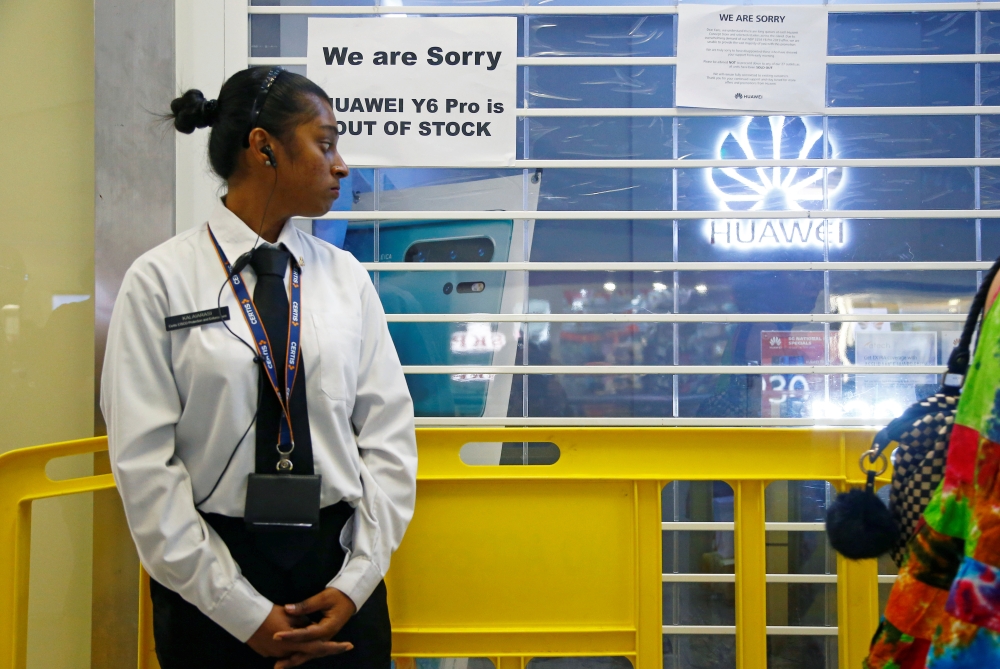 A security officer stands guard outside a closed Huawei store in Singapore on Friday. — Reuters