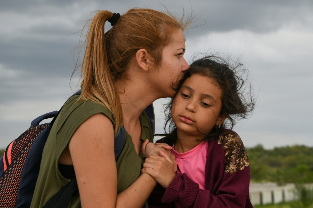 Madelen and seven year-old daughter Sophia, Venezuelan migrants, turn themselves in to law enforcement to seek asylum after illegally crossing the Rio Grande near Mission, Texas on Thursday. -Reuters photo
