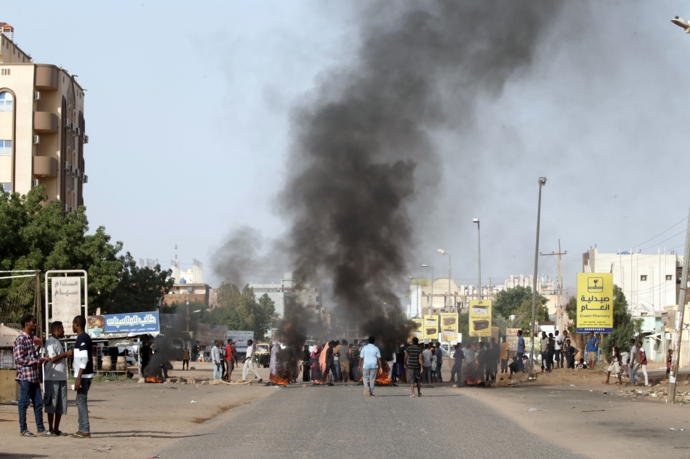 Demonstrators burn tires in the middle of a main street in Khartoum on Saturday, as they protest against the results of the probe into the June raid on a Khartoum protest camp revealed. — AFP