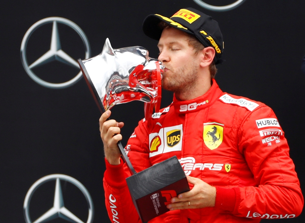 Ferrari's Sebastian Vettel celebrates with the second placed German Grand Prix trophy on the podium at Hockenheimring, Hockenheim, Germany, on Sunday. — Reuters