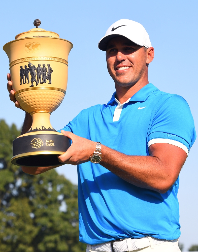 Brooks Koepka with the World Golf Championships trophy after winning the FedEx St. Jude Classic golf tournament at TPC Southwind at Memphis, TN, USA, on Sunday. — Reuters